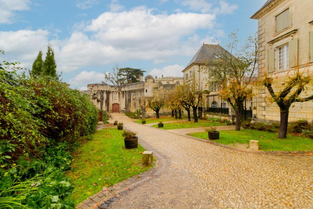 a cobblestone road in front of a building at Charme et Elegance a Bourdeilles in Bourdeilles