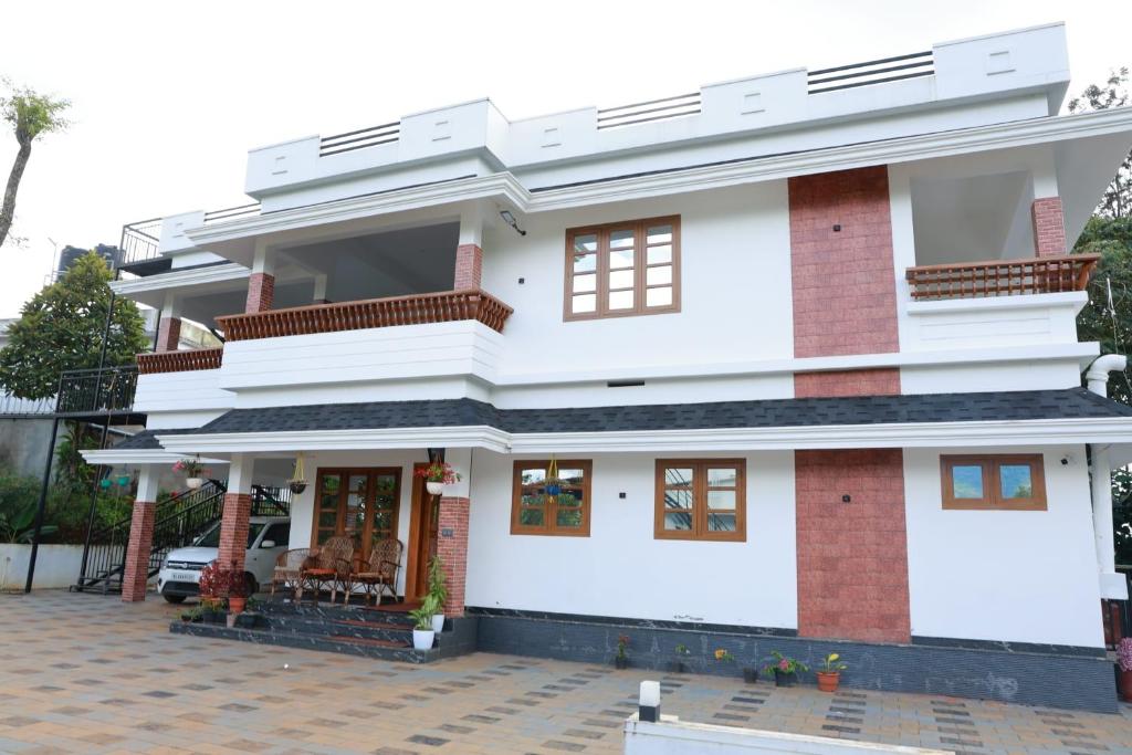 a white house with red bricks at Rain Drops Homestay in Anachal