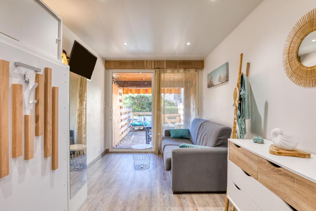 a living room with a couch and a table at Petit nid douillet in Cap d'Agde