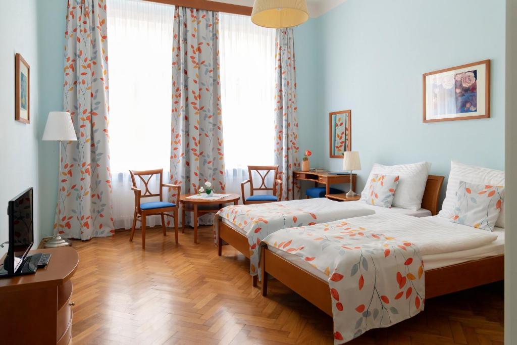 ein Schlafzimmer mit zwei Betten und einem Tisch und Stühlen in der Unterkunft Sibelius Apartments in Prag