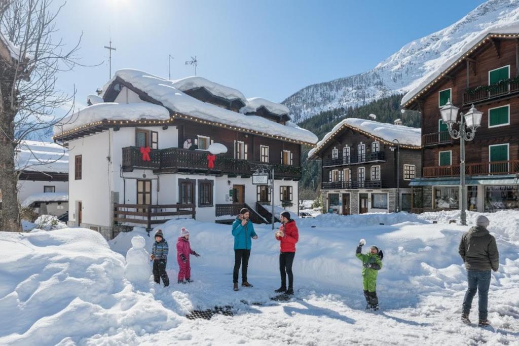 eine Gruppe von Menschen, die im Schnee stehen in der Unterkunft Incanto Walser Apartments Piazza in Macugnaga