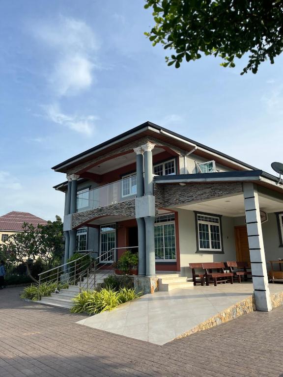 a large house with a porch and a patio at Ankyease Aclove in Kotrope