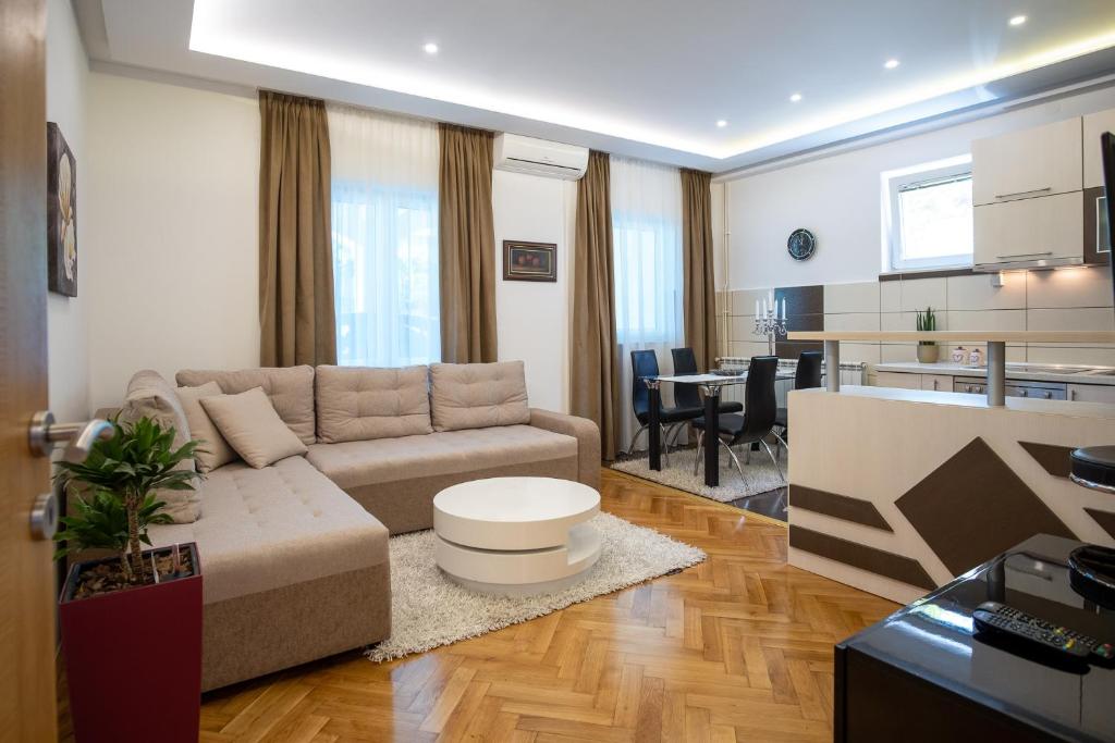 ein Wohnzimmer mit Couch und Küche in der Unterkunft City Apartments Premium in Trebinje