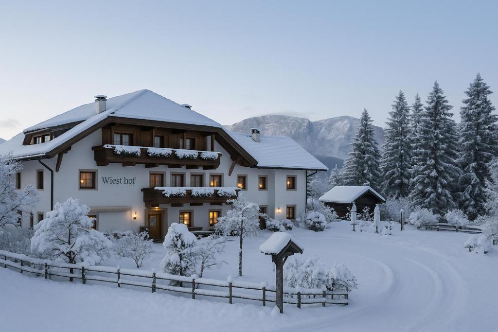 una casa en la nieve con árboles nevados en Hotel Wieslhof, en Collepietra