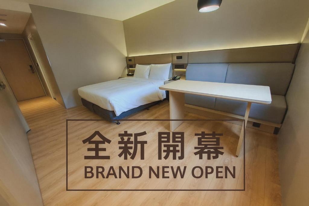 Una habitación con una cama y un cartel que dice nuevo abierto en 丰居中壢 Via Hotel Zhongli, en Zhongli