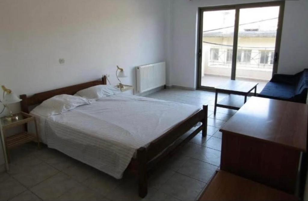 una camera da letto con un letto, un tavolo e una finestra di Tilde by the square, apt Argostoli ad Argostoli