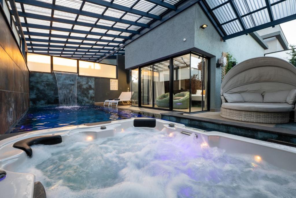 a jacuzzi tub in the middle of a house at Naomi Boutique Suites in Netu'a