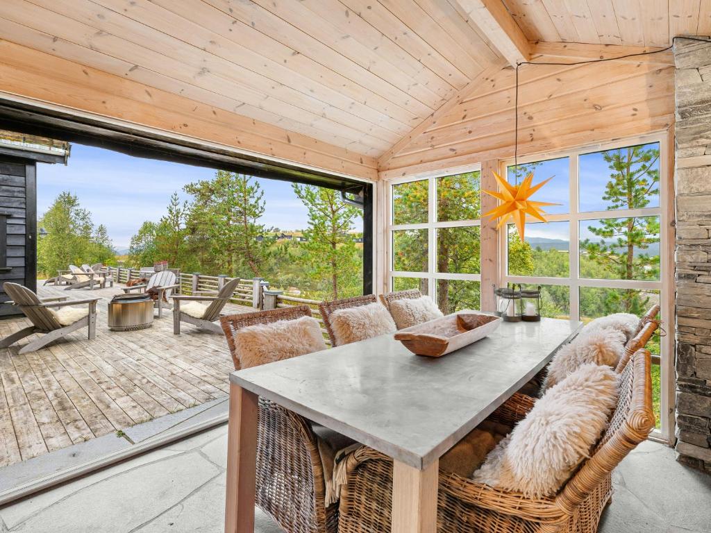 a dining room with a table and chairs on a patio at Family Cabin With Hot Tub In Hønedalen in Haugen