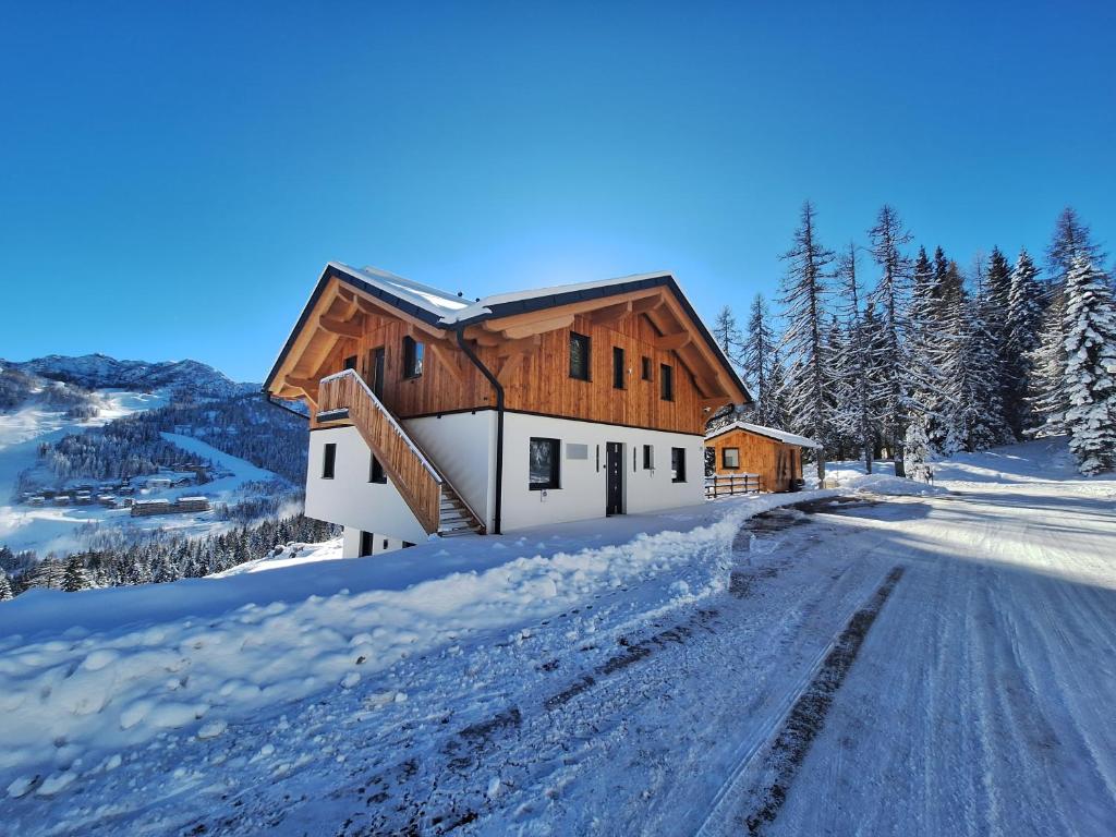 una casa nella neve su una strada innevata di Almhaus Hochenwarter a Sonnenalpe Nassfeld