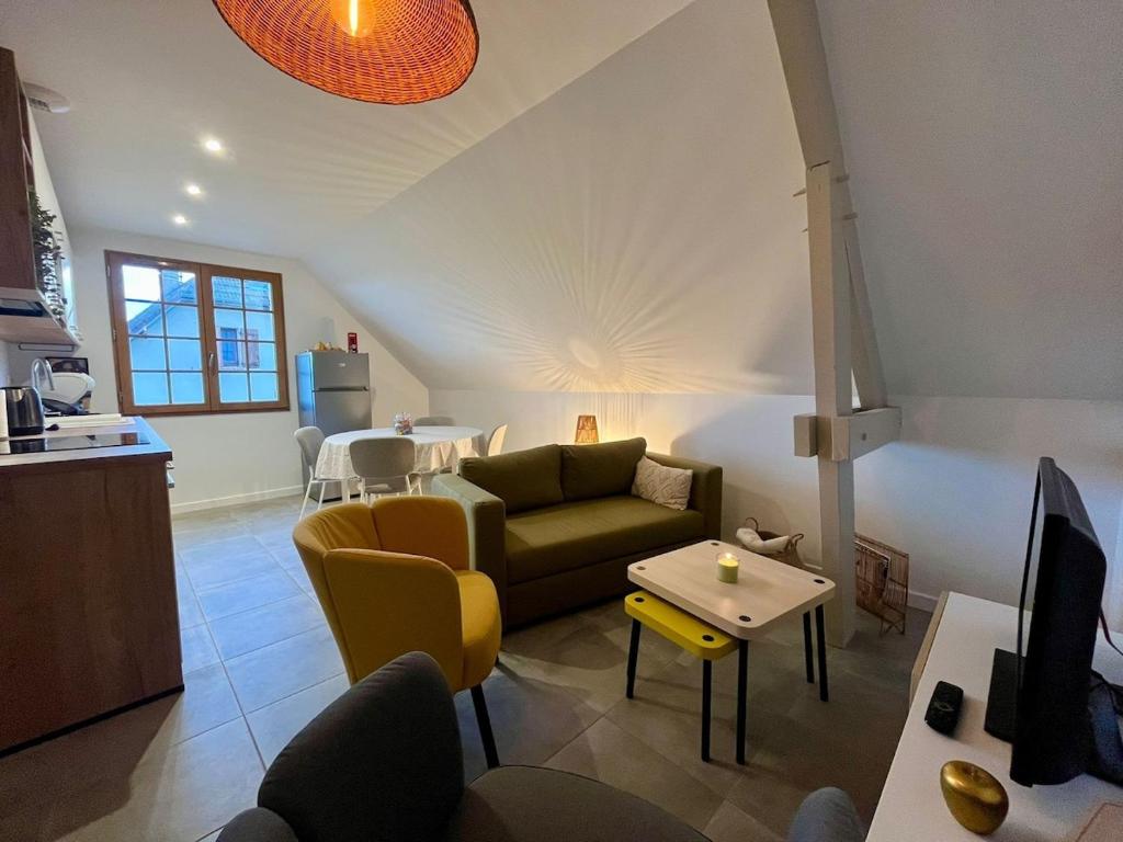 a living room with a couch and a table at L'Escale Champenoise - independent accommodation in Hautvillers
