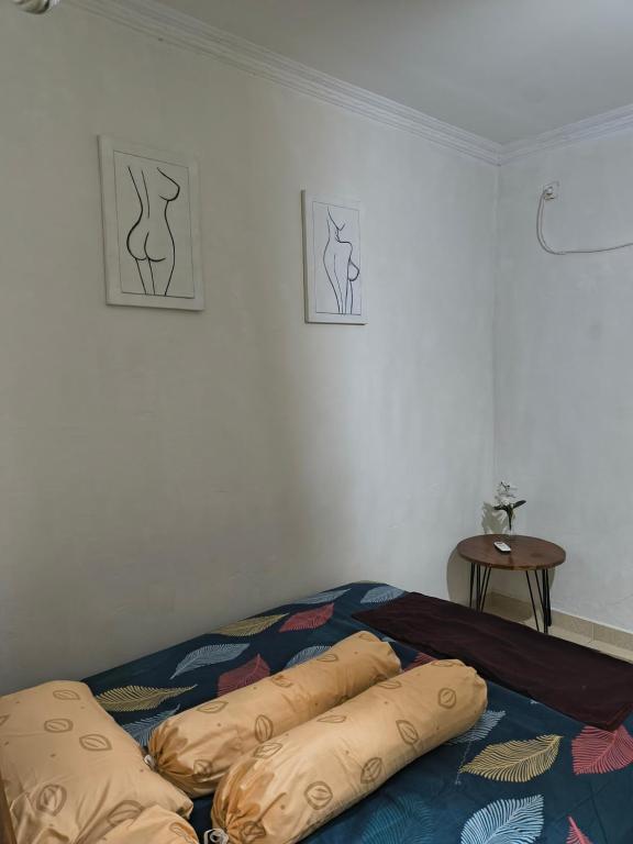 Un dormitorio con una cama con almohadas encima. en Little Loti Sikumana, en Maulafa