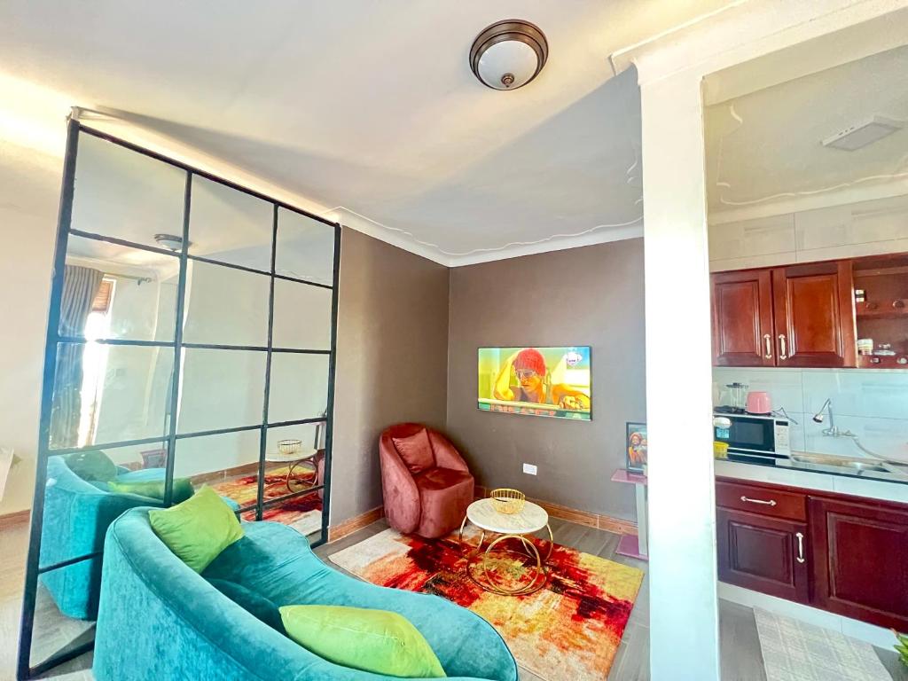 a living room with a blue couch and a table at Kampala Studio with Lake Breeze in Kampala