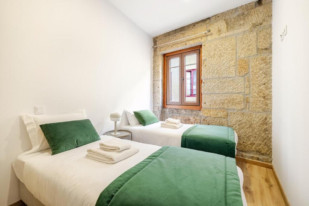 two beds with green and white sheets in a room at Two 2 Two Urban Stay in Vila Real