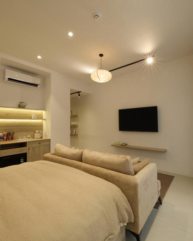 a bedroom with a bed and a flat screen tv at Lens Stay in Ho Chi Minh City