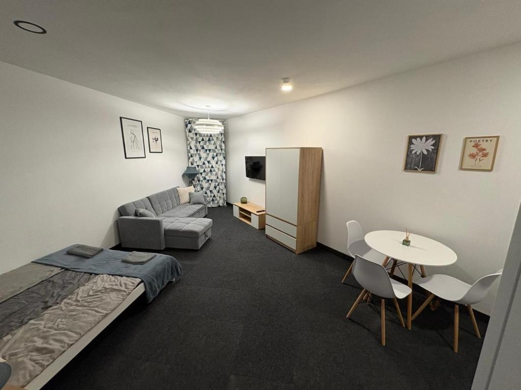 een kamer met een bed, een bank en een tafel bij Apartament pod wieżą in Głogów