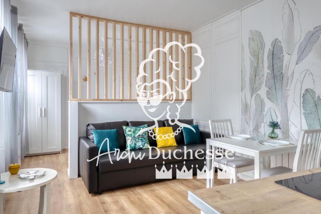 ein Wohnzimmer mit einer schwarzen Couch und einem Tisch in der Unterkunft Blue Bird charmant studio avec place de parking ! in Rouen