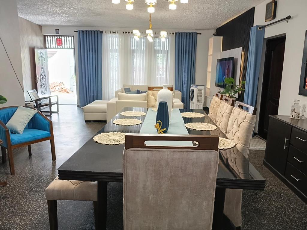 een woonkamer met een tafel en een bank bij Bernies Blue Heaven in Colombo