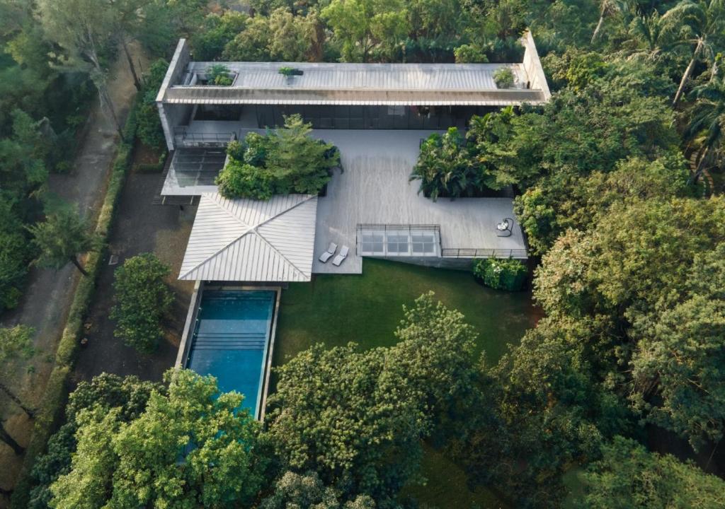an aerial view of a house in the middle of a river at LohonoStays Villa Gomti in Lonavala