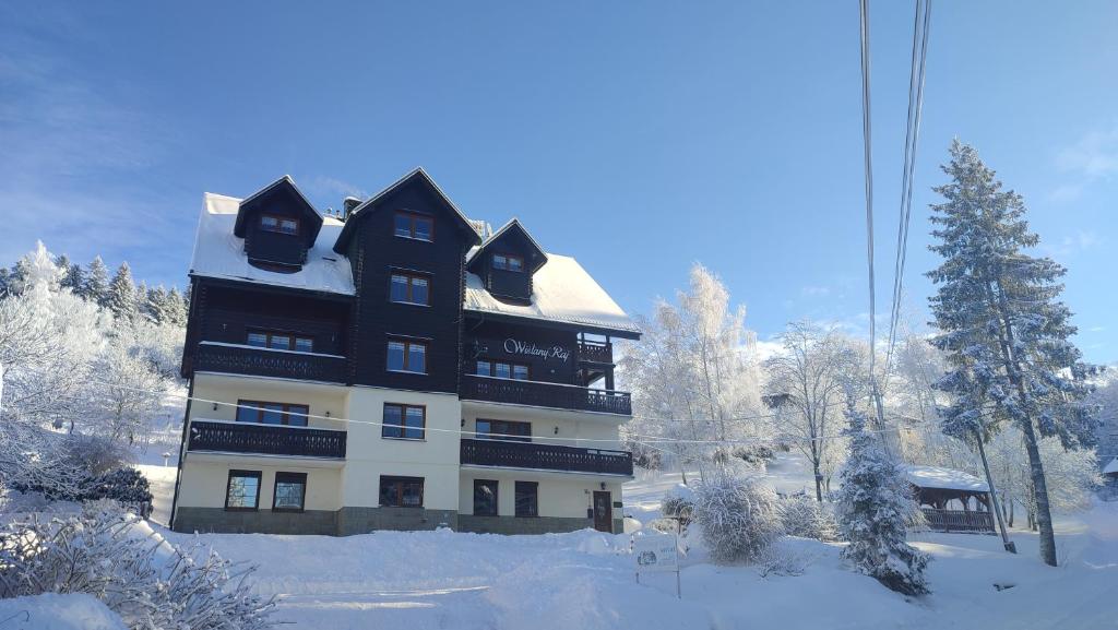 ein schwarzweißes Gebäude im Schnee in der Unterkunft Wiślany Raj in Wisła