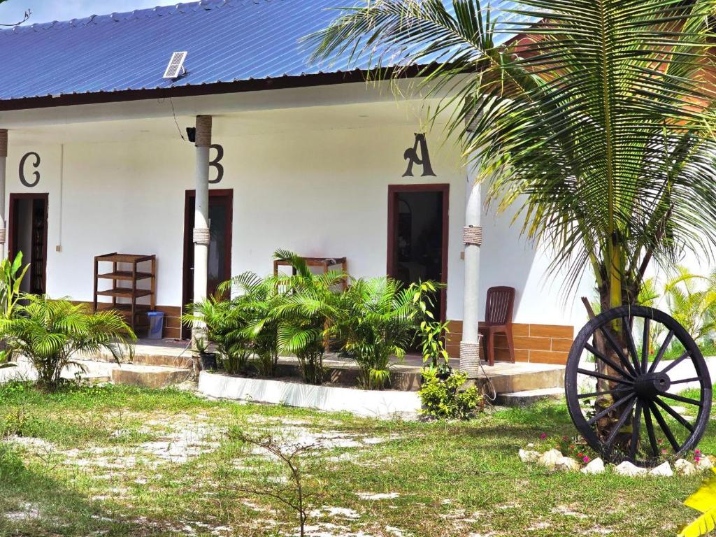 una casa con una rueda delante de ella en White Beach Hostel, en Koh Rong