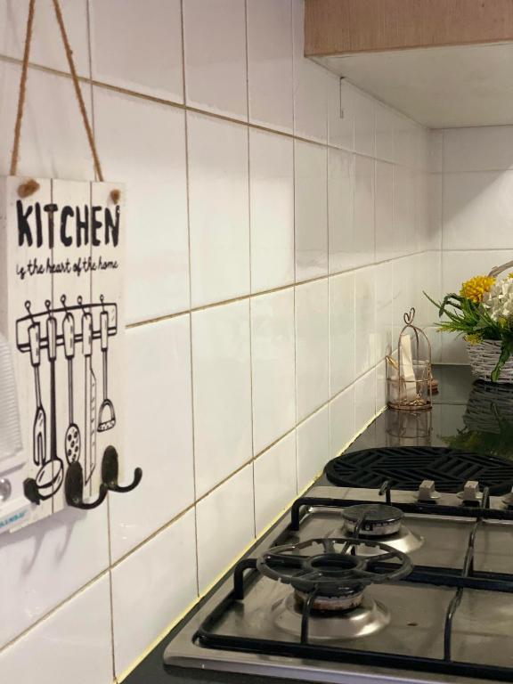 a stove top in a kitchen with a tile wall at Guildford room near Cafe and Train in Guildford