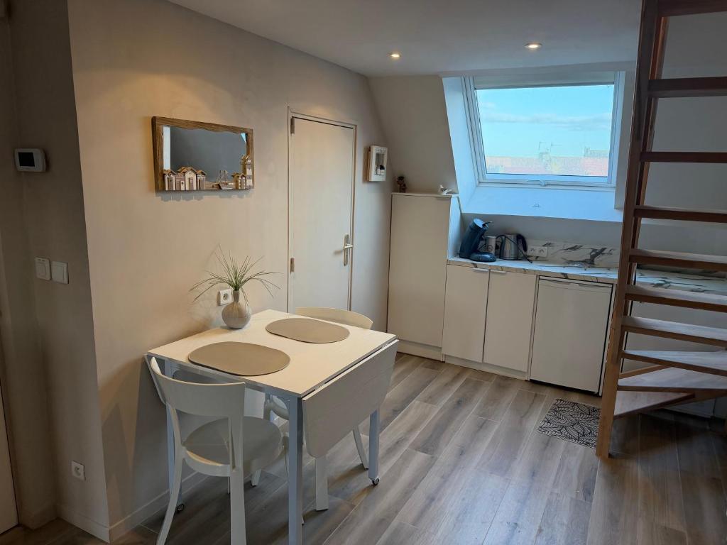 a kitchen with a table and chairs and a window at Appartement Duplex -Vue sur mer- à 100 m de la plage in Le Portel