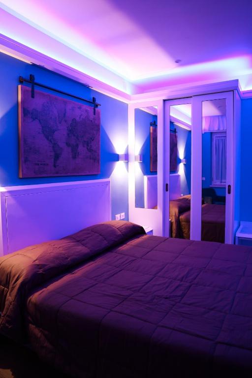 a bedroom with a large bed with a blue lighting at Hotel Miravalle in Naples