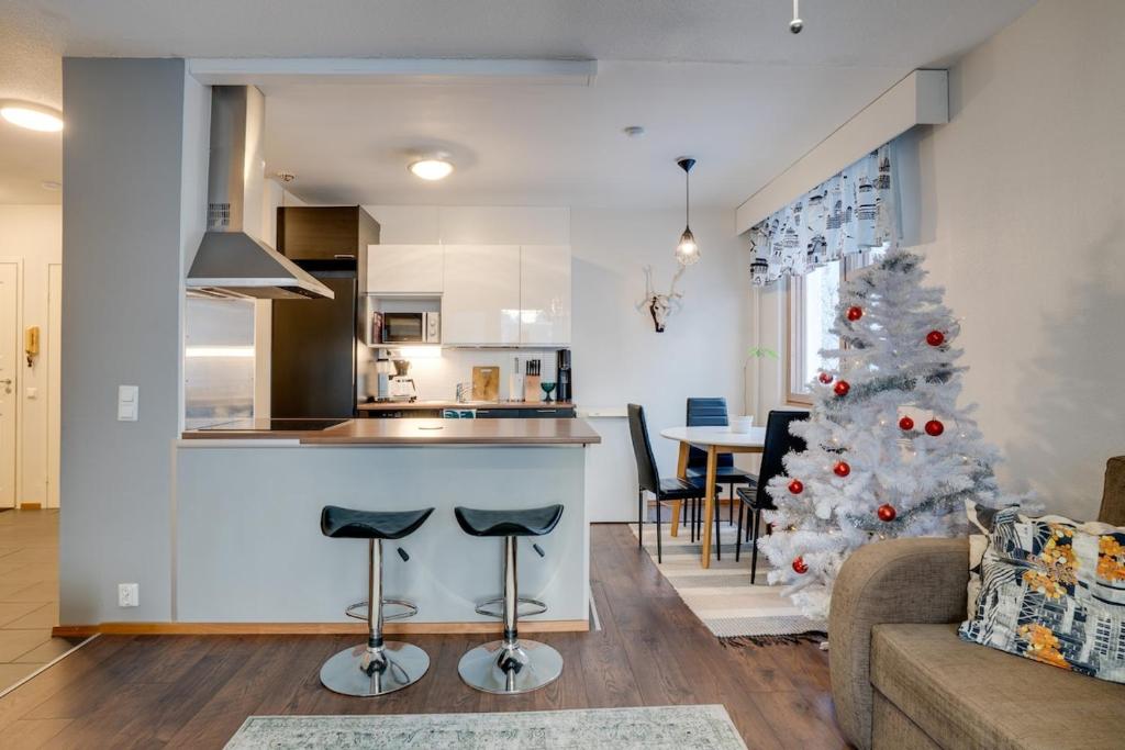 a living room and kitchen with a christmas tree at Matti's Charming Studio in Rovaniemi