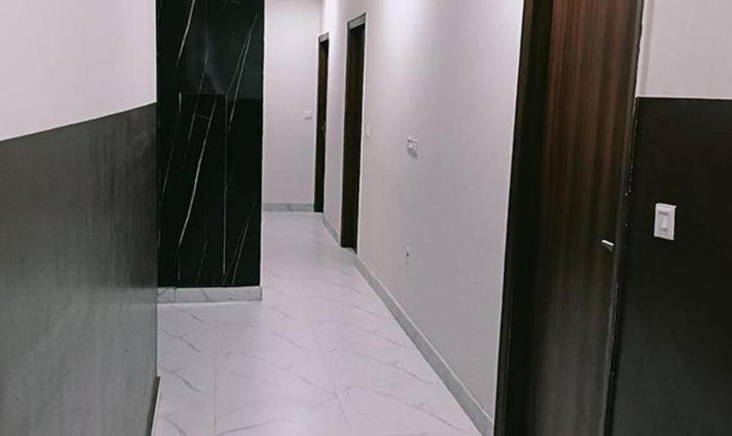 pasillo con puertas y suelo de baldosa en un edificio en FabHotel Kalka Residency, en Nueva Delhi