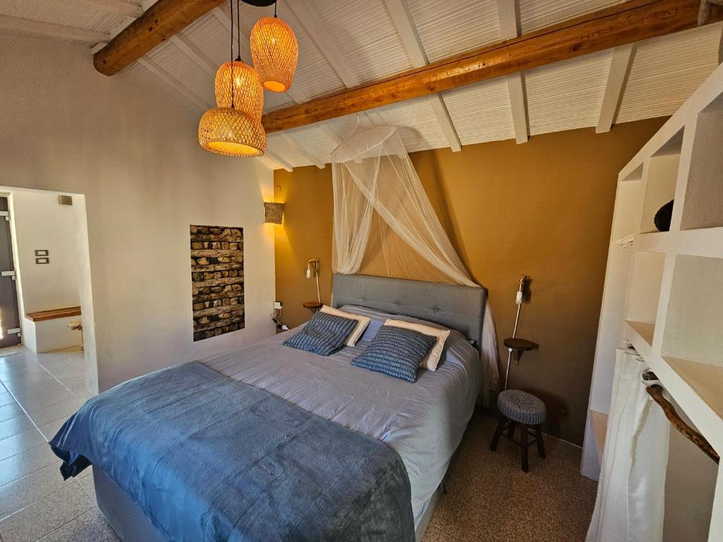 a bedroom with a bed with two blue pillows at Tramontana Casetta in Castilenti