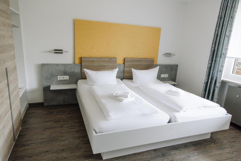 a bedroom with two beds with white sheets at Landgasthof Freiberger in Schnabelwaid