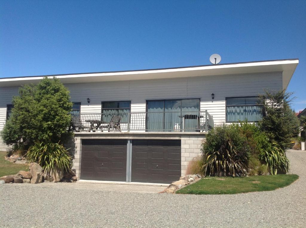 a house with two garage doors and a balcony at The Bach in Lake Tekapo