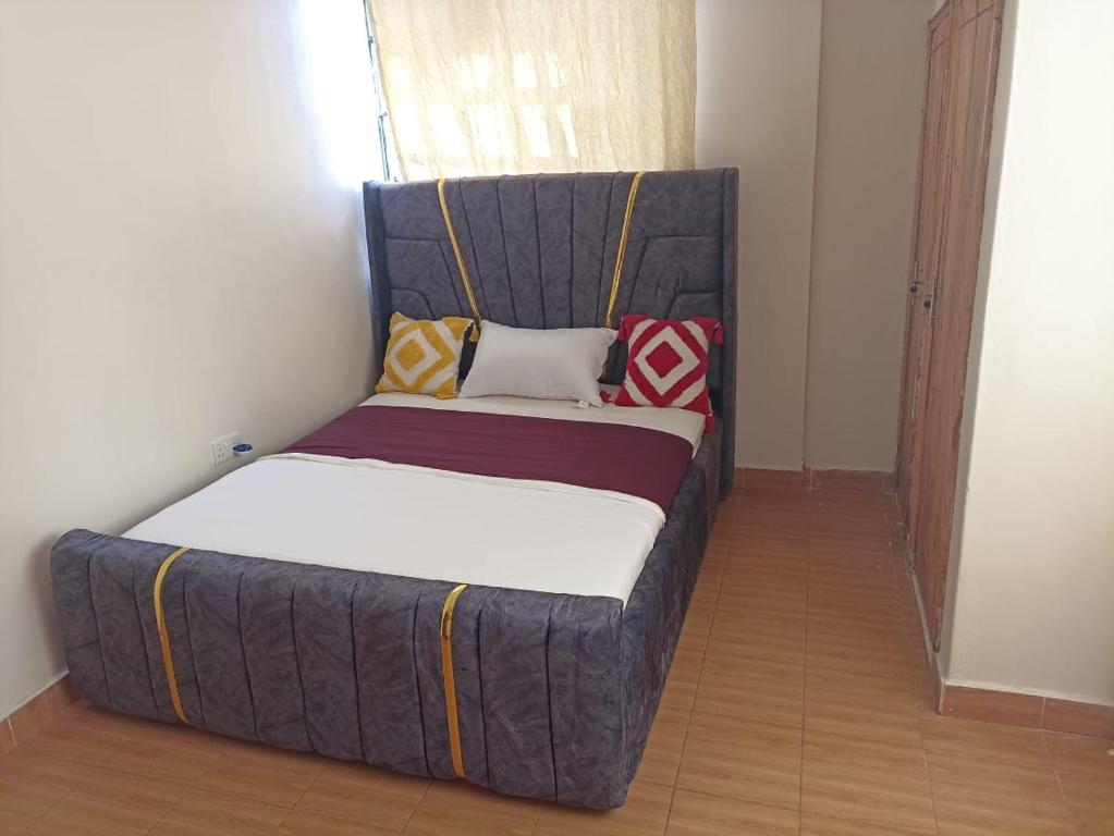 a bed sitting in a corner of a room at Jay homes in Kakamega