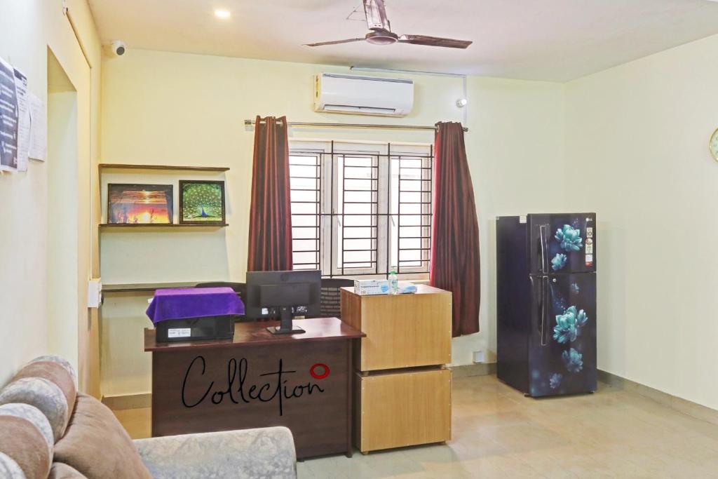 a living room with a couch and a table and a refrigerator at Collection O Orchid Residency Medavakkam in Chennai