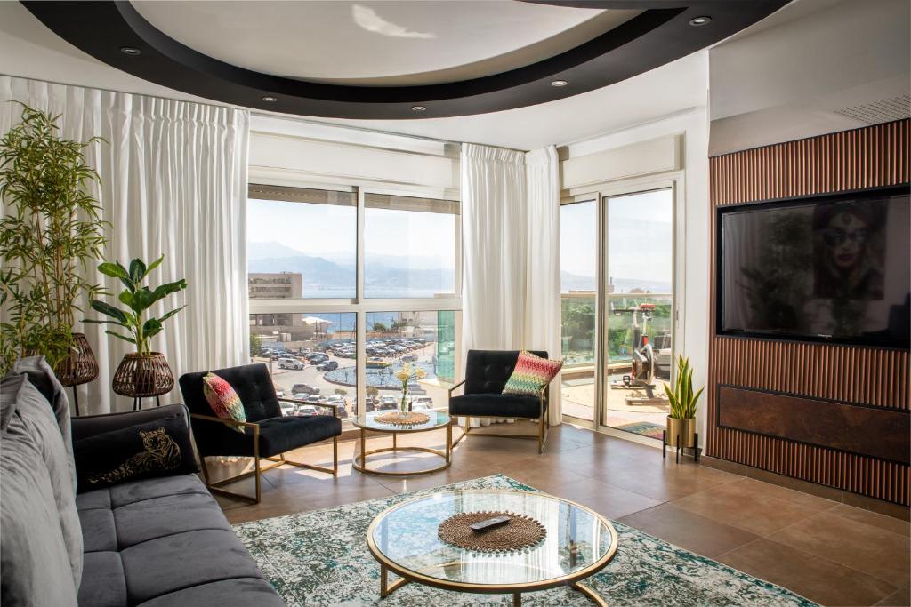 una sala de estar con un sofá y una mesa en מילה דירות אירוח - Skyline Eilat, en Eilat