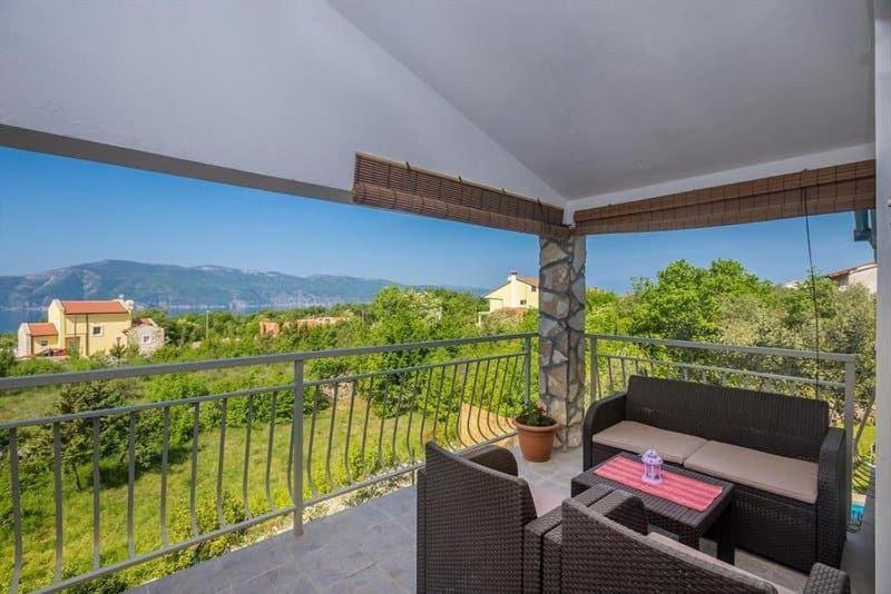a patio with a table and chairs on a balcony at Olive Garden Krk in Brzac