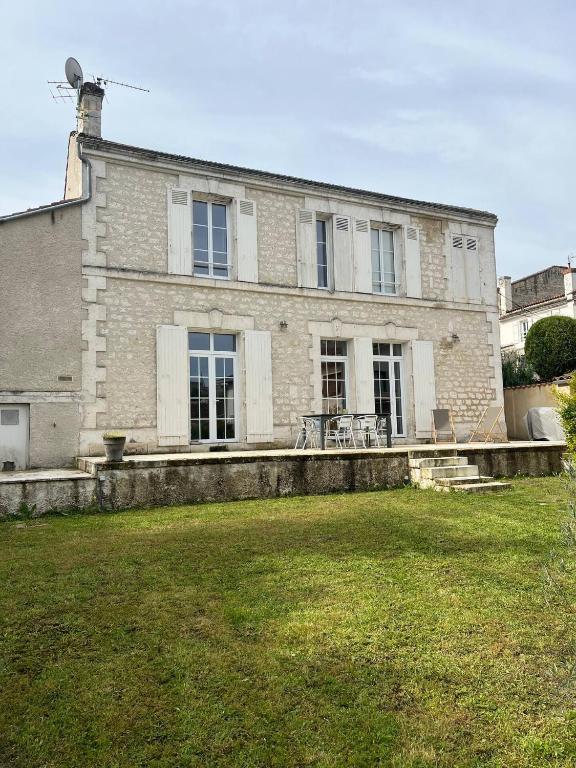 a large brick house with a grass yard in front of it at Maison 6 personnes Angouleme in Angoulême