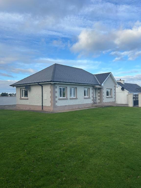 a house with a large green lawn in front of it at Carnglas, Gweedore, County Donegal in Donegal