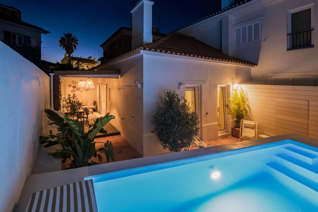 a villa with a swimming pool at night at 2BR Private Pool House Near Lisbon & Beaches in Parede