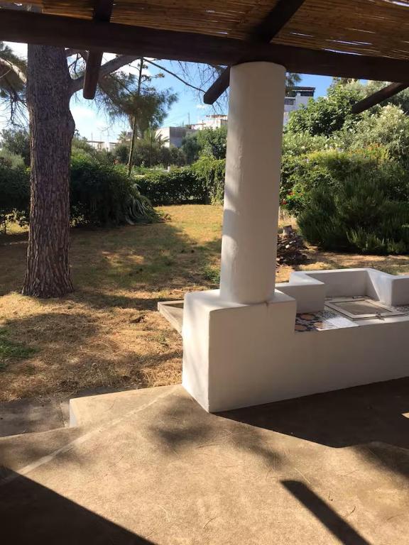 a porch with a white pillar and a tree at Casa Moser in Stromboli