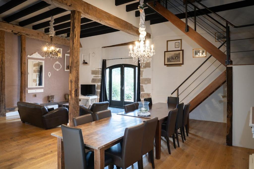 een eetkamer met een houten tafel en stoelen bij Maison 4 in Souvigny