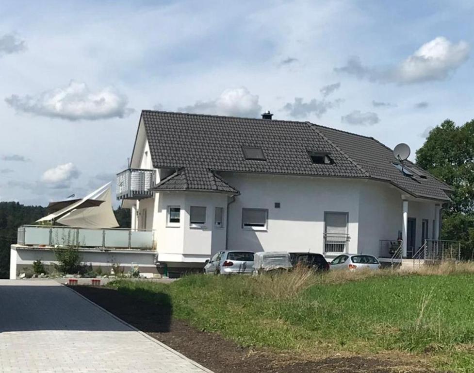 a white house with cars parked in front of it at Haus Stegmeir in Hohenweiler