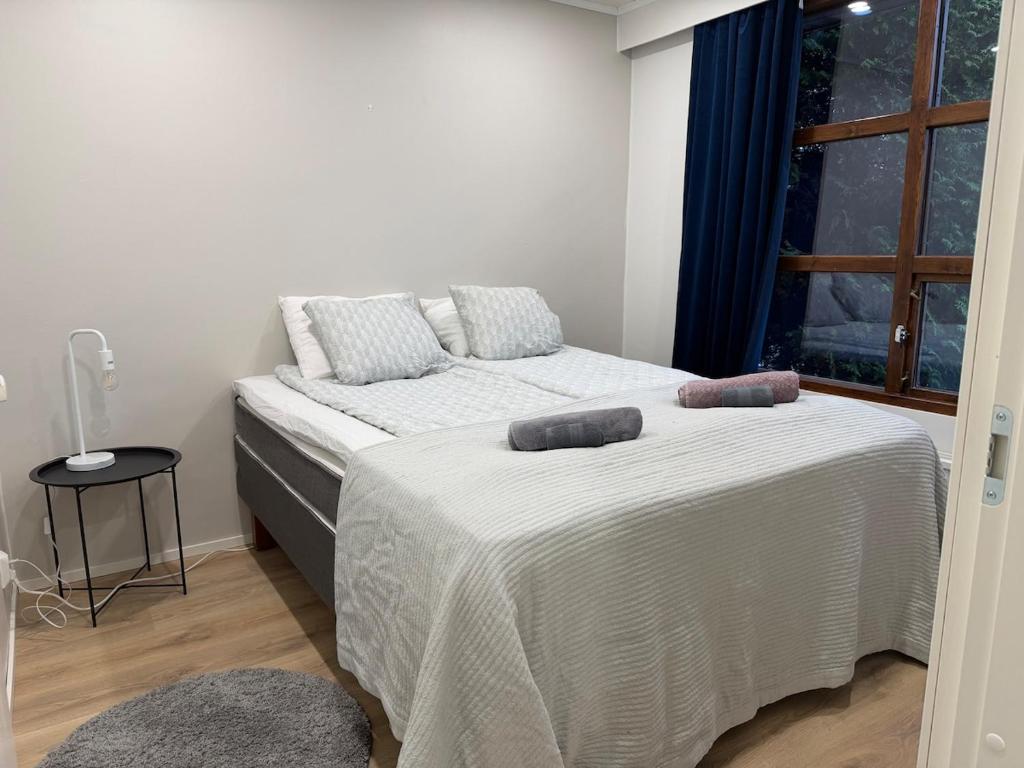 una camera da letto con due letti con lenzuola bianche e una finestra di Apartment Kaarto a Seinäjoki