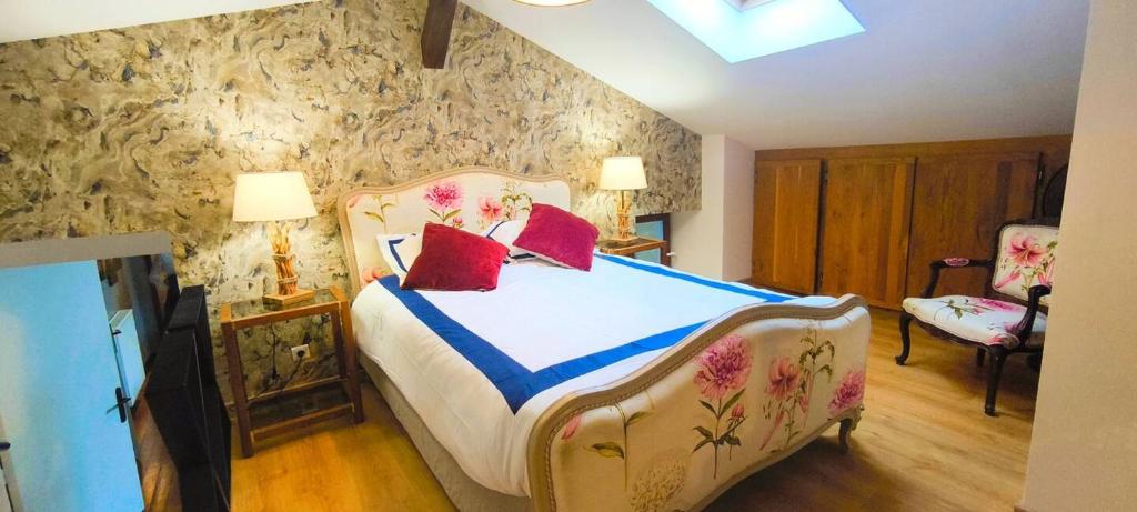 una camera da letto con un letto grande con cuscini rossi di Gite de Marthon, 10 personnes a Marthon