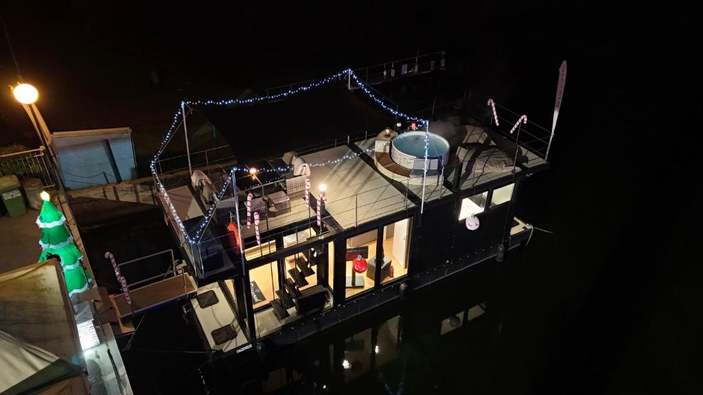 a boat with lights on the deck at night at DIAMOND Bigigio House Boat in Lisanza