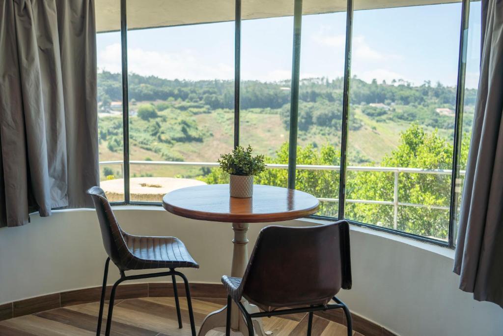 a table and two chairs in front of a large window at 1/4 na Serra in Rio Maior