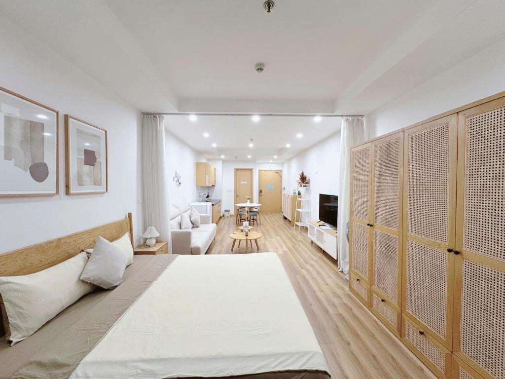 Un dormitorio con una cama grande y una sala de estar en TMS Quy Nhơn - Hupasearest Apartment SeaView, en Quy Nhon