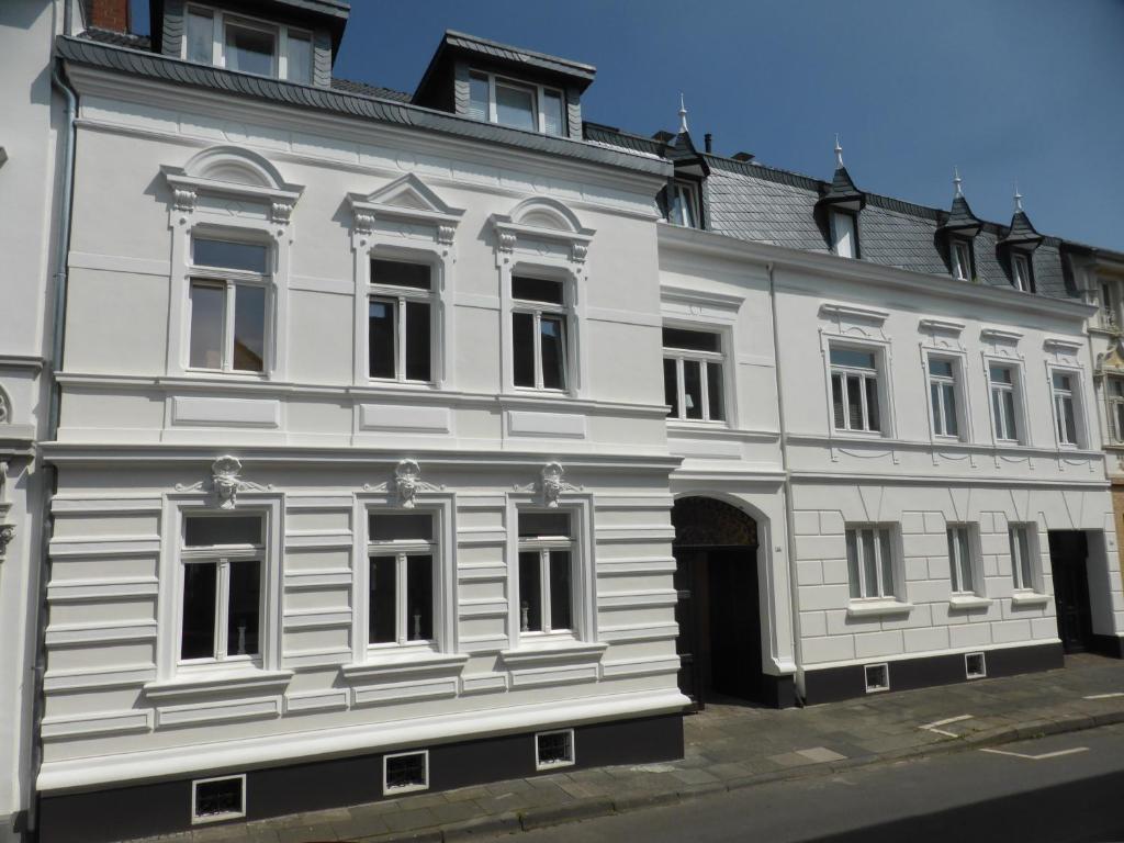 ein weißes Gebäude mit vielen Fenstern in der Unterkunft Arkadenschlösschen Bonn in Bonn