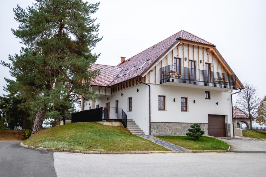a white house with a gambrel roof at Vineyard Escape Herbersteinova klet in Juršinci