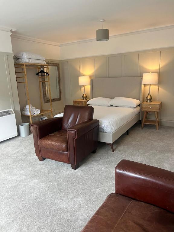 a bedroom with a bed and a couch and a chair at The OXTED high street studio in Oxted
